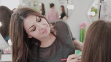 Profesyonel makyöz kadın palette makyaj kremi karıştırıyor..
