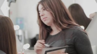 Profesyonel makyöz kadın palette makyaj kremi karıştırıyor..