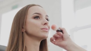 Profesyonel makyöz kadın palette makyaj kremi karıştırıyor..