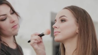 Profesyonel makyöz kadın palette makyaj kremi karıştırıyor..