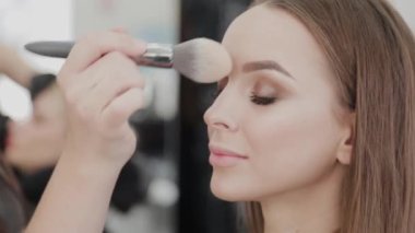 Profesyonel makyöz kadın palette makyaj kremi karıştırıyor..