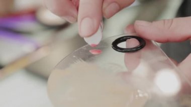 Profesyonel makyöz kadın palette makyaj kremi karıştırıyor..