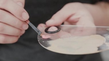 Profesyonel makyöz kadın palette makyaj kremi karıştırıyor..