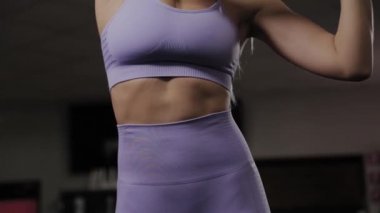 Güzel vücutlu atletik bir kadın antrenmandan önce esneme hareketleri yapar..