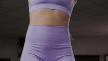 Güzel vücutlu atletik bir kadın antrenmandan önce yatay çubukta gerinir..