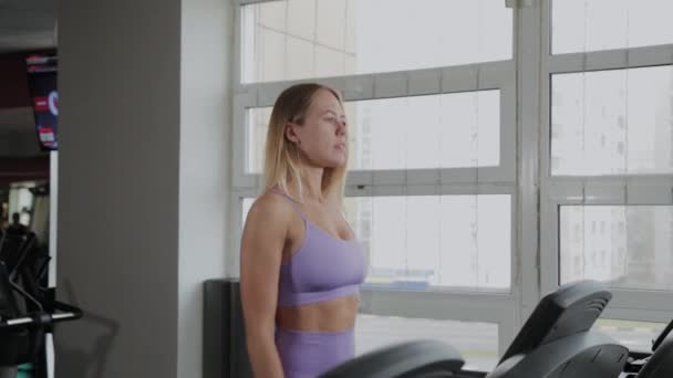 아름다운 몸매를 가진 운동 선수 여자가 러닝 머신에서 훈련하고 있습니다. — 비디오