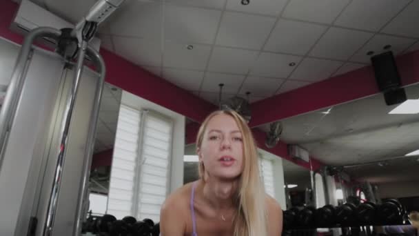 Спортивная женщина с красивой фигурой тренируется с гирями в спортзале . — стоковое видео