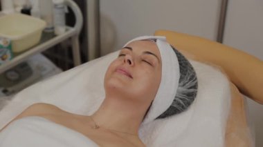 Bir kadın ameliyattan önce kozmetik uzmanı tarafından kanepeye uzanır..