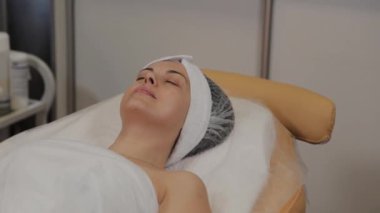 Bir kadın ameliyattan önce kozmetik uzmanı tarafından kanepeye uzanır..