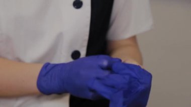 Profesyonel güzellik uzmanı mavi lastik eldiven giyer..