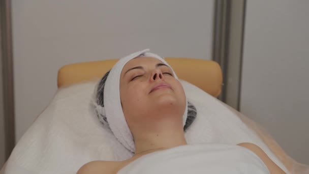 Una donna si trova su un divano da un cosmetologo prima della procedura . — Video Stock