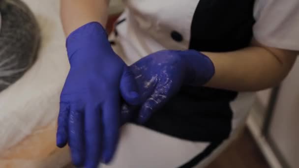 プロの美容師はオイルスクラブの手を笑顔. — ストック動画
