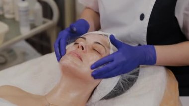 Profesyonel kadına yüz masajı yaptırır..