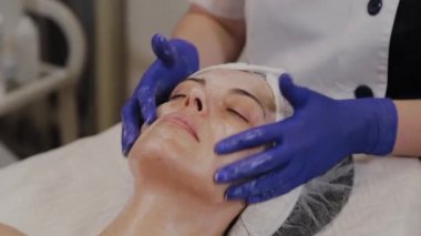 Profesyonel kadına yüz masajı yaptırır..