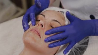 Profesyonel kadına yüz masajı yaptırır..