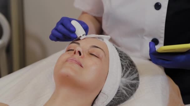 Професійний косметолог вимірює стан шкіри за допомогою інструменту . — стокове відео