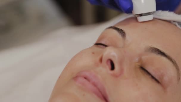 En professionell kosmetolog mäter hudens tillstånd med hjälp av ett instrument. — Stockvideo