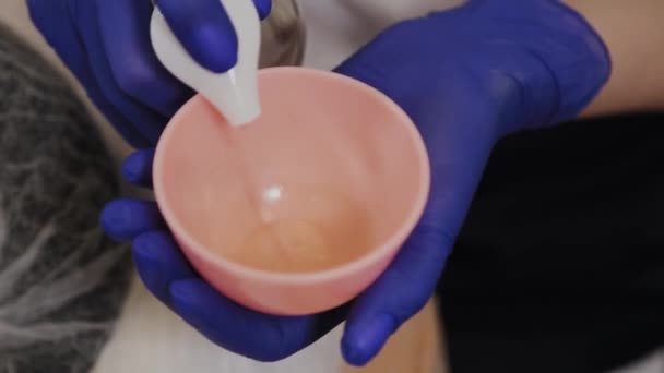 Professional beautician pours facial serum into a bowl. — Stock Video