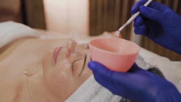Professzionális kozmetikus alkalmazza arc szérum ecsettel. — Stock videók