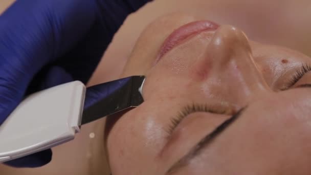 Professionelle Kosmetikerin macht Ultraschall-Gesichtsreinigung für Frauen mittleren Alters. — Stockvideo