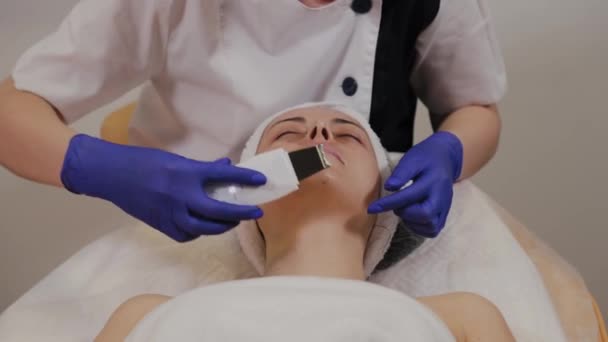 Esthéticienne professionnelle fait nettoyage du visage par ultrasons pour femme d'âge moyen . — Video