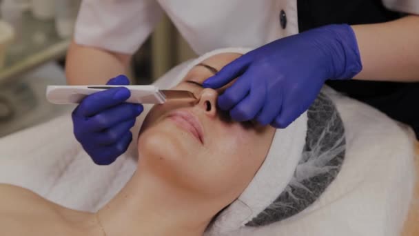 Professionele schoonheidsspecialiste doet ultrasone gezichtsreiniging voor vrouwen van middelbare leeftijd. — Stockvideo