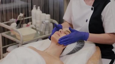 Profesyonel kadına yüz masajı yaptırır..