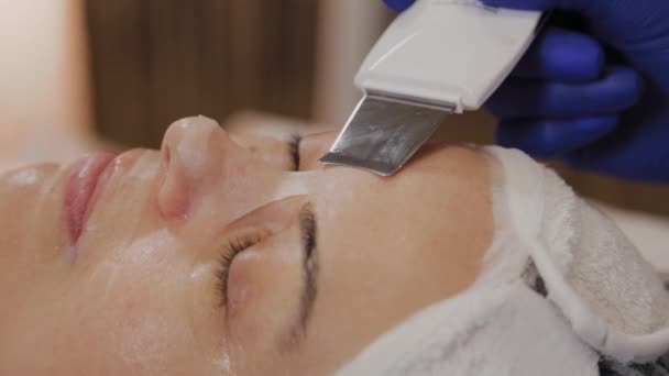Profesjonalny kosmetyk robi ultradźwiękowe czyszczenie twarzy dla kobiet w średnim wieku. — Wideo stockowe
