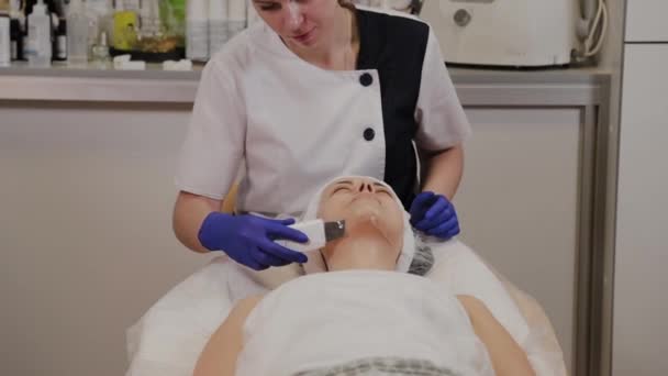 プロの美容師は中年女性のための超音波顔のクリーニングを行います. — ストック動画