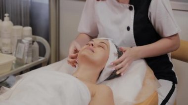 Profesyonel kadına yüz masajı yaptırır..
