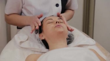 Profesyonel kadına yüz masajı yaptırır..