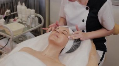 Profesyonel kadına yüz masajı yaptırır..