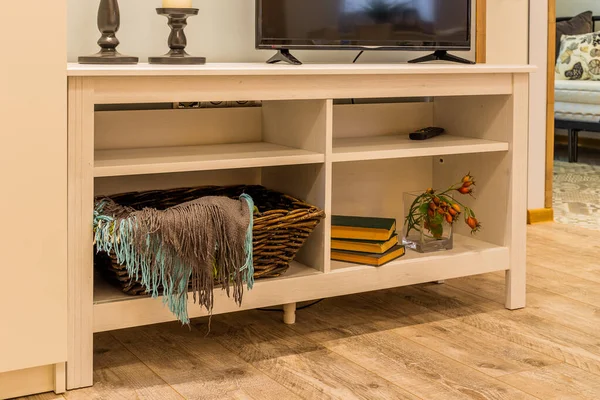 Wooden white TV stand in the interior of the house.