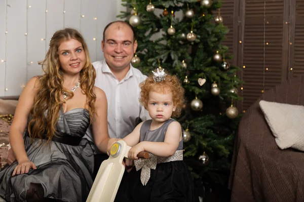 Vacker ung lycklig familj med ett barn på nyårsafton på soffan. Nytt år 2020. — Stockfoto