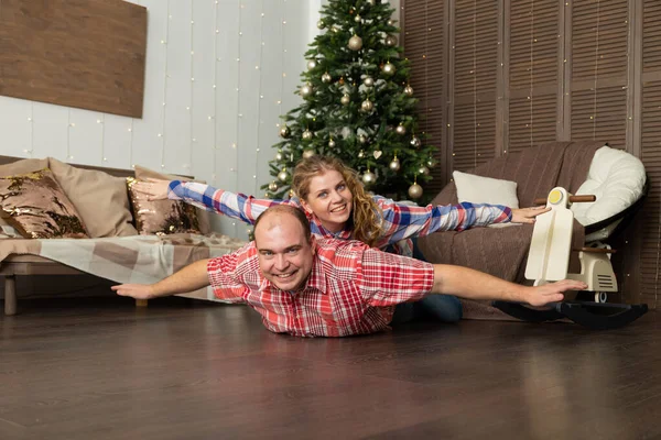 Jeune couple heureux amoureux sur le sol par l'arbre du Nouvel An . — Photo