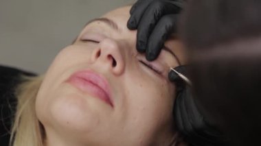 Güzellik salonunda profesyonel bir güzellik uzmanı kirpik temizleme prosedürü uygular..