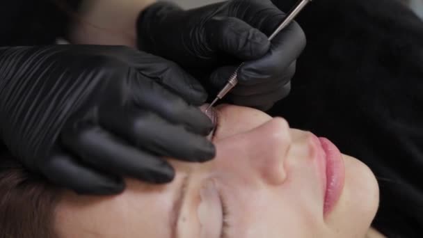 Eine professionelle Kosmetikerin in einem Schönheitssalon führt eine Wimpernlaminierung durch. — Stockvideo