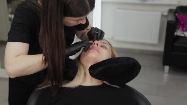 Eine professionelle Kosmetikerin in einem Schönheitssalon führt eine Wimpernlaminierung durch. — Stockvideo