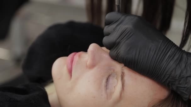 A professional beautician in a beauty salon performs eyelash lamination procedure. — Stock Video