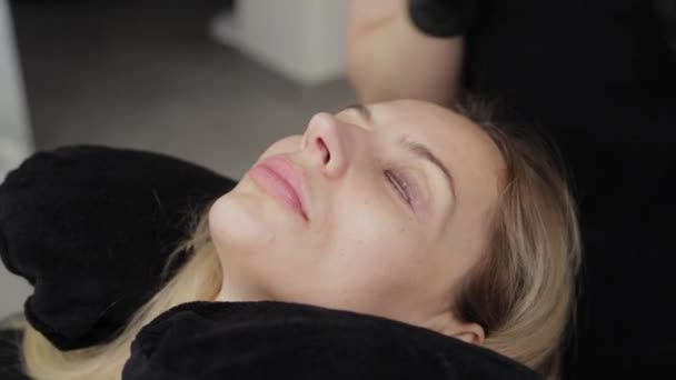 Профессиональный косметолог в салоне красоты наносит гель для ламинирования ресниц на ресницы клиента . — стоковое видео