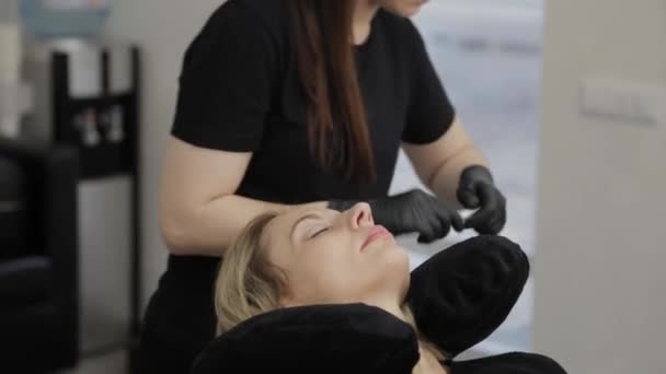 Eine professionelle Kosmetikerin in einem Schönheitssalon führt eine Wimpernlaminierung durch. — Stockvideo