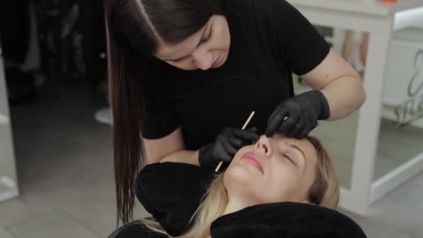 Professionel kosmetolog i skønhedssalon. Kosmetolog gør øjenvipper rengøring . – Stock-video