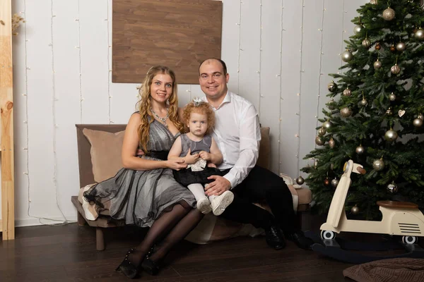 Krásná mladá šťastná rodina s dítětem na Silvestra na gauči. Nový rok 2020. — Stock fotografie