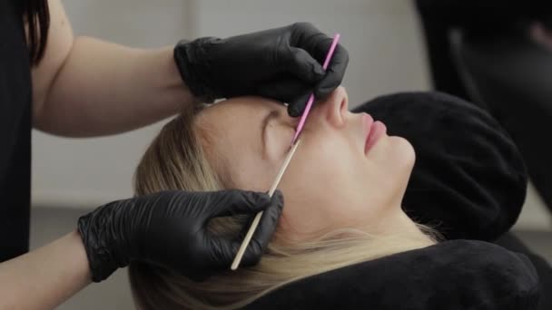 Professionell kosmetolog i skönhetssalong. Vackra gör ögonfransar rengöring. — Stockvideo