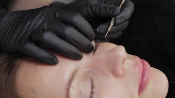 Een professionele schoonheidsspecialiste in een schoonheidssalon voert wimper lamineren procedure. — Stockvideo