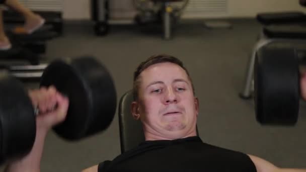 Strong athlete performs bench press dumbbell. — Stock Video