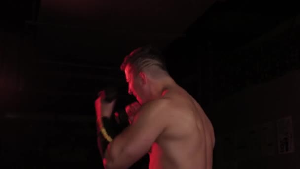 Boxe uomo atletico con manubri in illuminazione rossa . — Video Stock