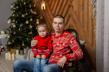 Yeni yıl dekorunda oğlu olan mutlu bir adam. Mutlu Noeller 2020.