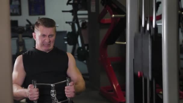 Atleta fuerte realiza un ejercicio de levantamiento de pesas en un bloque . — Vídeos de Stock