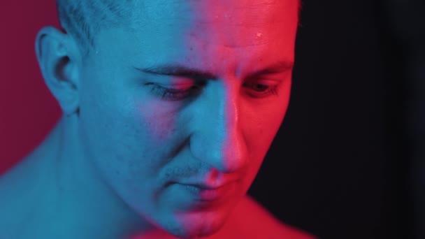Vackert ansikte av en sportig man i rött-blått ljus. — Stockvideo